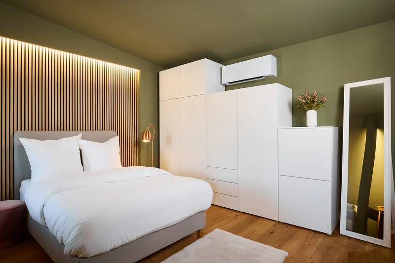 Ferienwohnung Stadium: Schlafzimmer mit Holzlamellen-Akzentwand